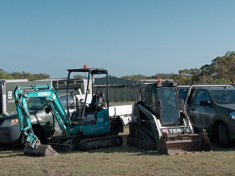 Mini excavator and tracked loader ready for residential excavation and site preparation.